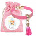 Pulsera rosa con borlón en bolsa de tela a juego con adhesivo personalizado para bautizos